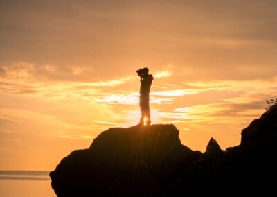 a person standing on top of a rock near the ocean